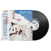 1000 Smiles Alsogood vinile LP nero con OBI edition disco in evidenza e copertina con architettura bianca mediterranea e cielo blu