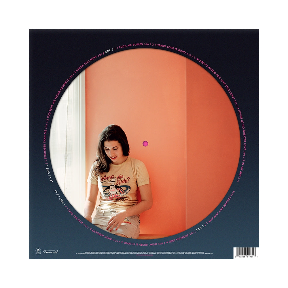 nuova immagine di amy winehouse servizio fotografico del 2003 ocn sfondo arancione della cantante seduta su un muretto per la prima volta su picture disc dell'album frank